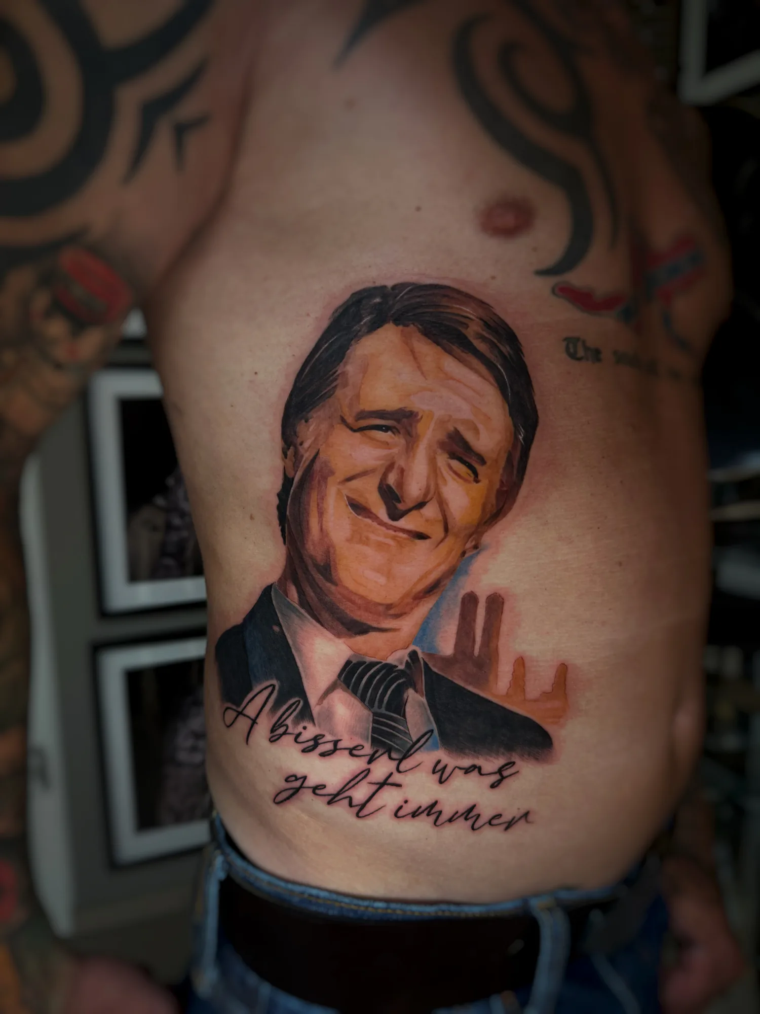 Farbiges Porträt-Tattoo an der Rippe mit Schriftzug