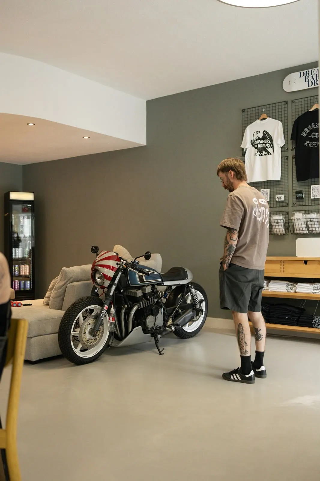 Wartebereich mit Motorrad, Sofa und Merch-Wand